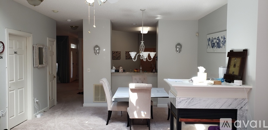 A dining room with a table and chairs.