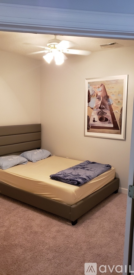 A bedroom with a bed and a ceiling fan.