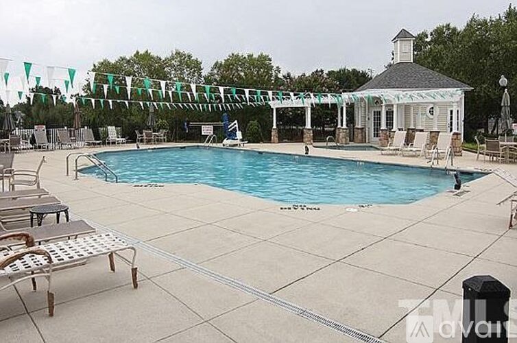 A pool with a gazebo and a few chairs.