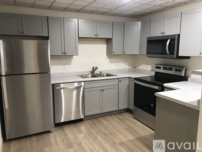 A kitchen with a stainless steel refrigerator and microwave.