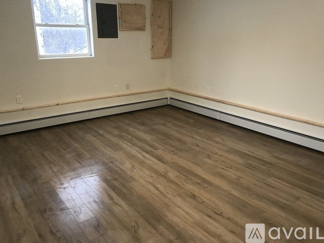 A room with wooden flooring and a window.