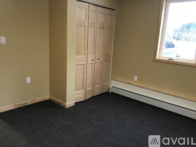 A room with a wooden door and a window.
