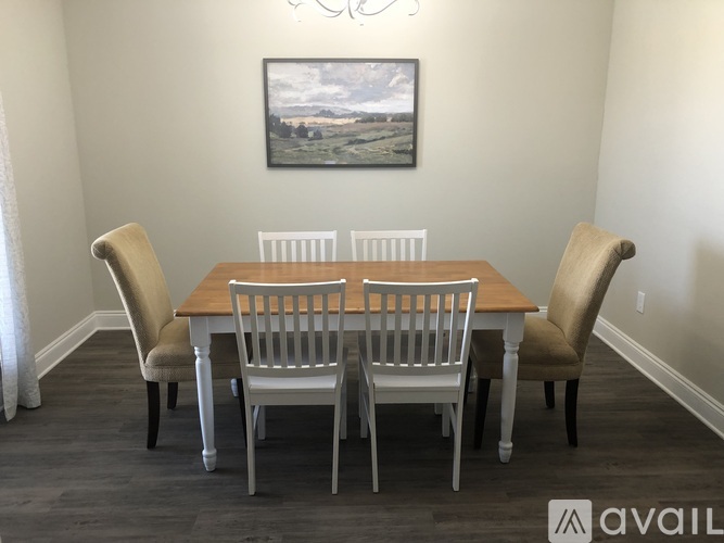 A dining room with a wooden table and chairs.
