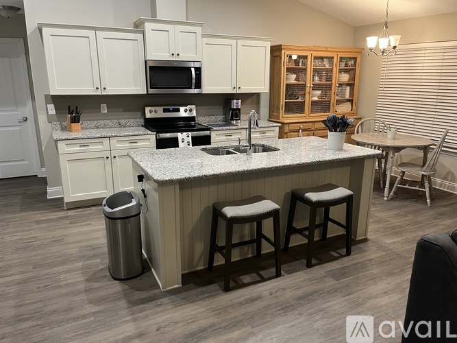 A kitchen with a white countertop and wooden cabinets.
