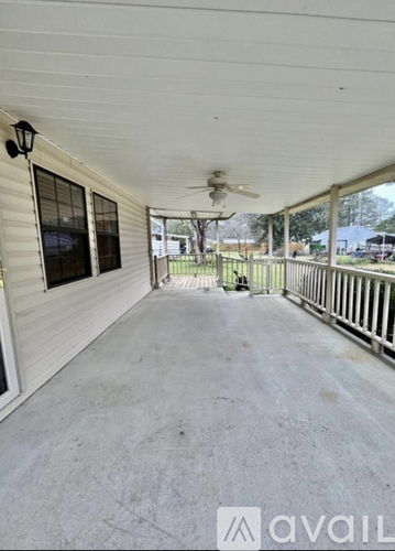 A porch with a fan and a light fixture.