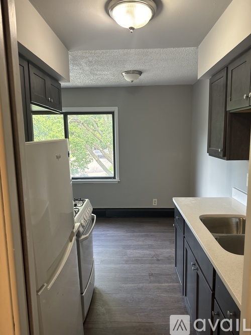 A kitchen with a white fridge and a window.