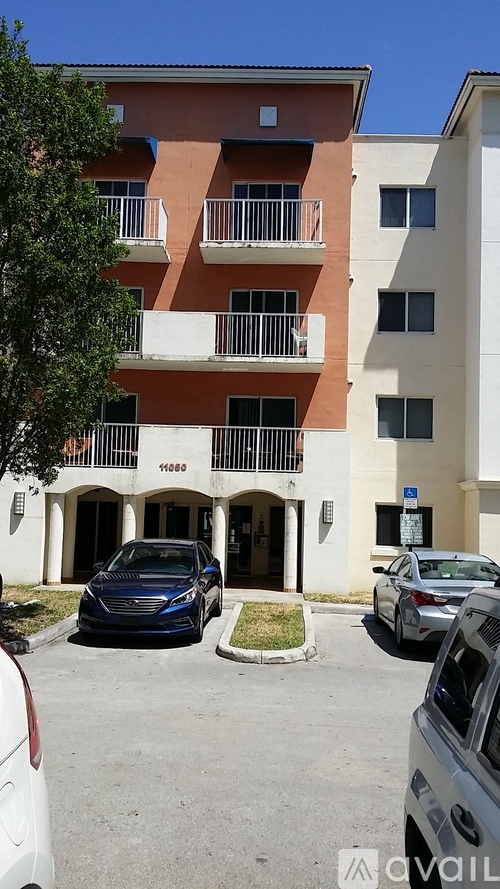 A multi-story apartment building with a parking lot in front.