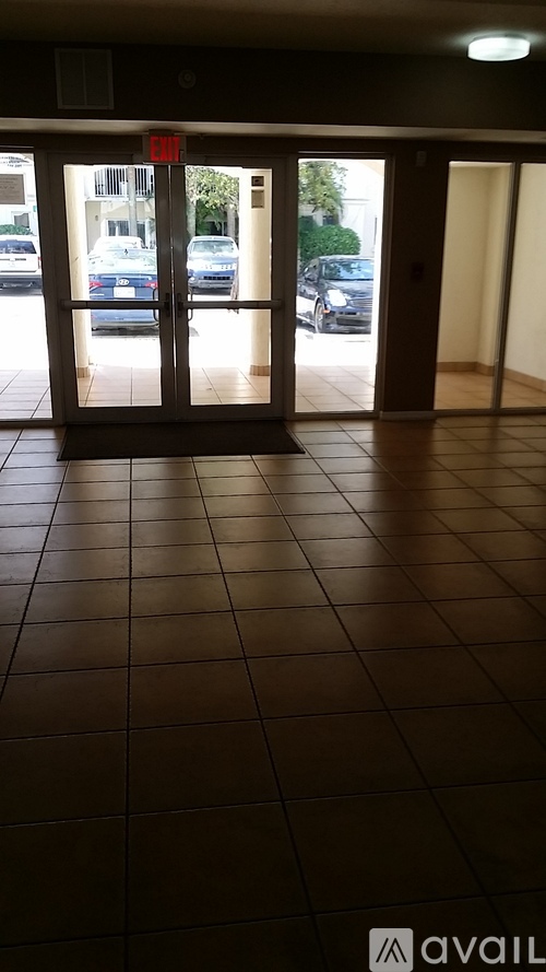 A tiled floor with a red exit sign above it.