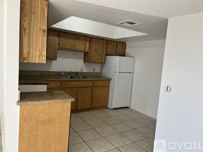 A kitchen with wooden cabinets and a white refrigerator.
