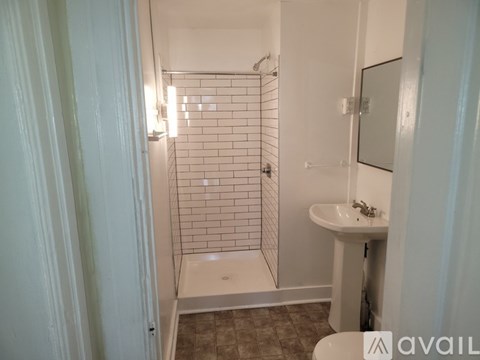 A bathroom with a white sink and a glass shower stall.