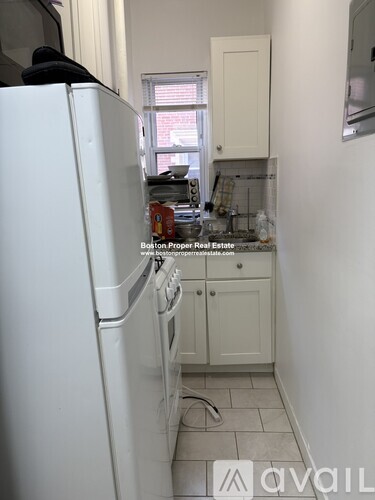 A kitchen with a white fridge and cabinets.