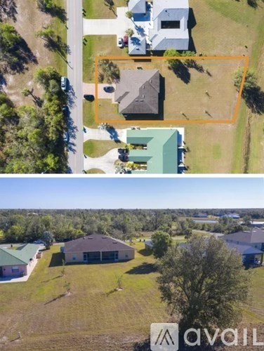 A bird's eye view of a property with a large house and a smaller one, surrounded by a fence and trees.
