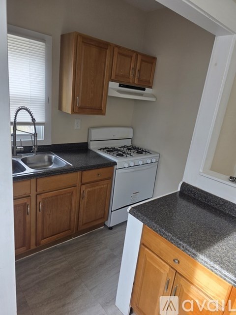A kitchen with a white stove top oven and a white dishwasher.