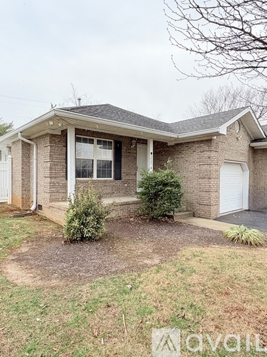 A house with a white garage door and a small front yard.