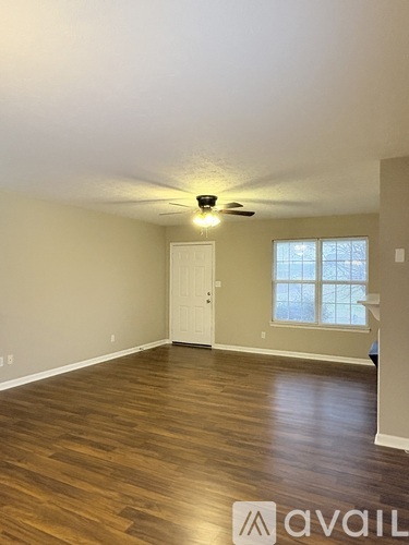 A room with wooden flooring and a ceiling fan.