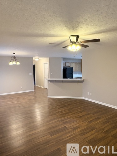 A room with wooden flooring and a ceiling fan.