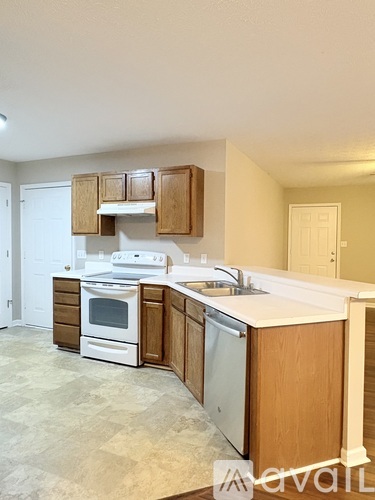 A kitchen with white appliances and wooden cabinets.