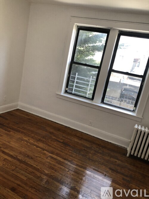 A room with a window and a radiator on the floor.