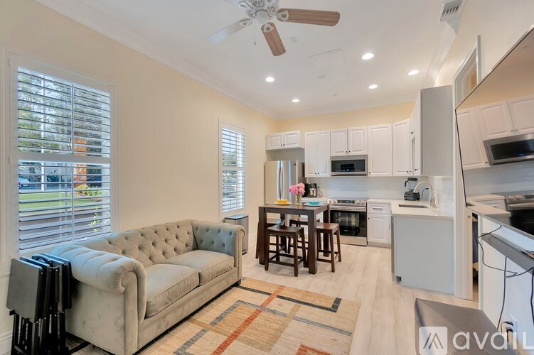 A living room with a couch, a bar, and a kitchen area.