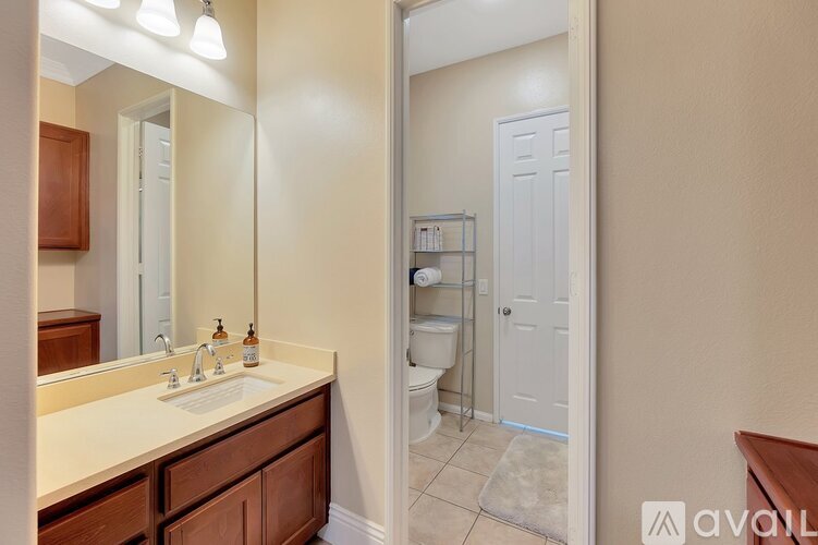 A bathroom with a sink, mirror, and toilet.