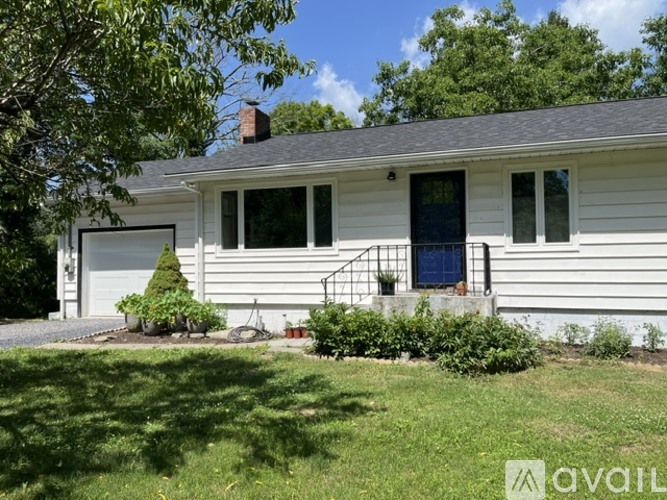 A house with a grey garage door and a blue door.