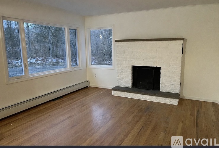 A room with a fireplace and wood flooring.