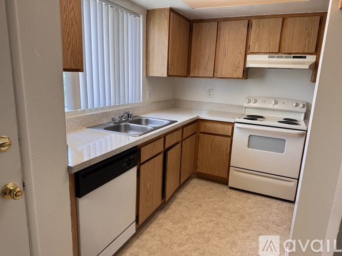 A kitchen with wooden cabinets and white appliances.