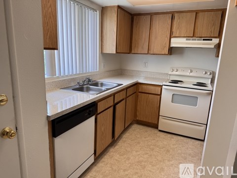 A kitchen with wooden cabinets and white appliances.