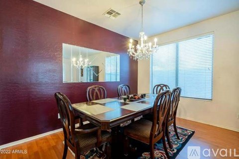 A dining room with a wooden table and chairs.