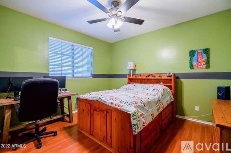 A bedroom with a bed, desk, and chair.
