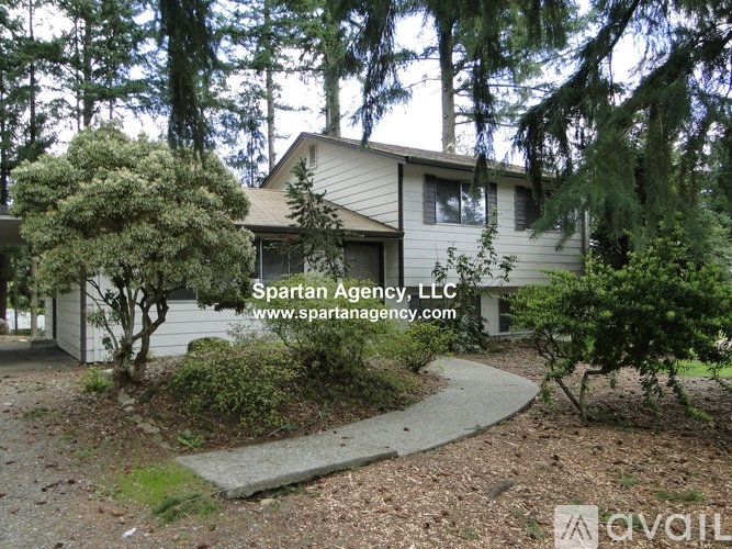 A house with a garden in front and the text "Spartan Agency, LLC" and a website address.