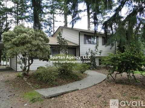 A house with a garden in front and the text "Spartan Agency, LLC" and a website address.