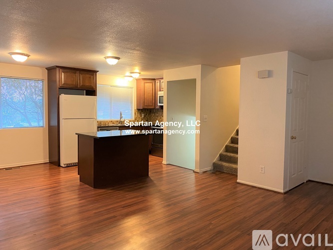 A kitchen with wooden cabinets and a black countertop.