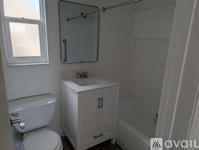 A white bathroom with a toilet, sink, and medicine cabinet.