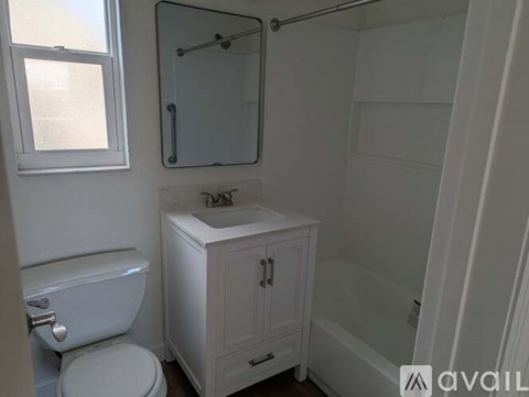 A white bathroom with a toilet, sink, and medicine cabinet.