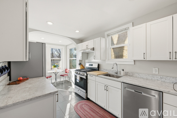 A modern kitchen with white cabinets and a marble countertop.