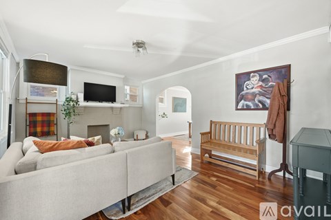 A living room with a grey couch and a wooden bench.