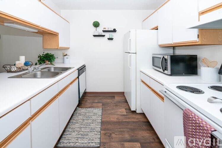 A kitchen with white cabinets and a black microwave.