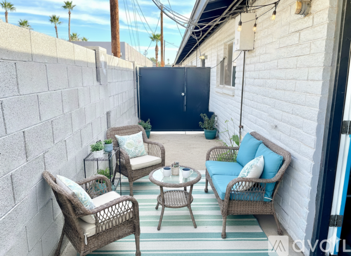 A patio with a wicker sofa, chairs, and a table.