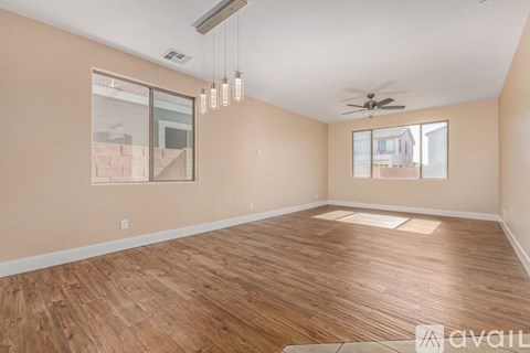 A room with a carpeted floor, a ceiling fan, and a window with curtains.
