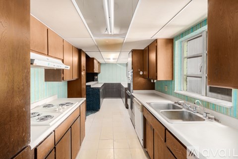A kitchen with wooden cabinets and a white counter top.