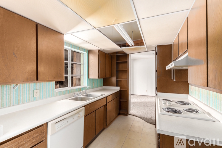 A kitchen with wooden cabinets and a white dishwasher.