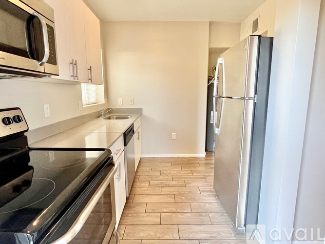 A kitchen with a black stove top oven and a black microwave above it.