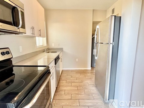 A kitchen with a black stove top oven and a black microwave above it.