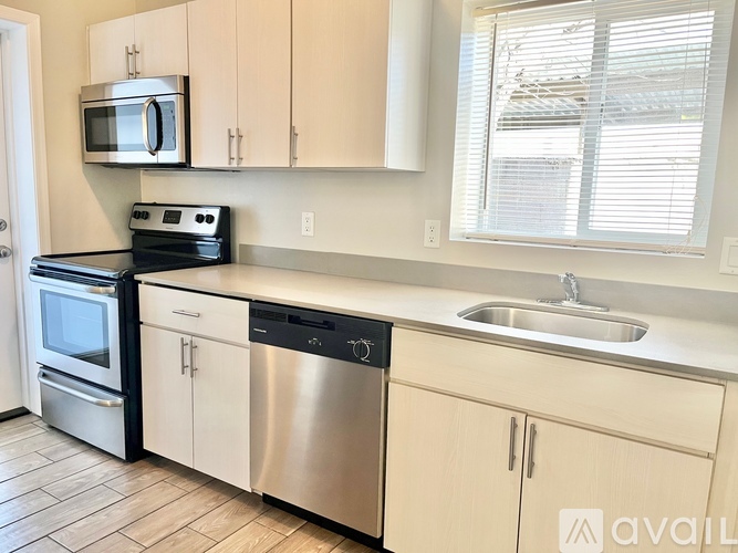 A kitchen with a stainless steel dishwasher and oven.
