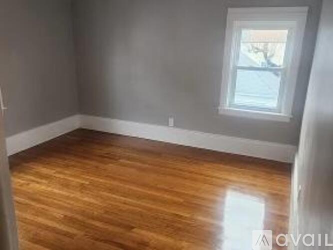 A room with wooden flooring and a window.