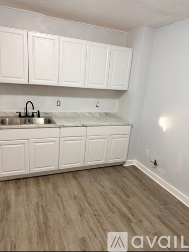 A kitchen with white cabinets and a sink.