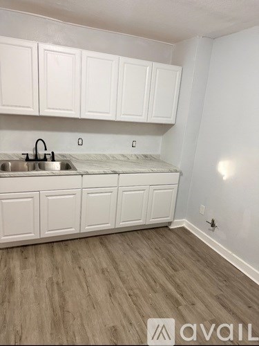 A kitchen with white cabinets and a sink.