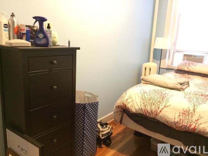 A bedroom with a bed, dresser, and window.