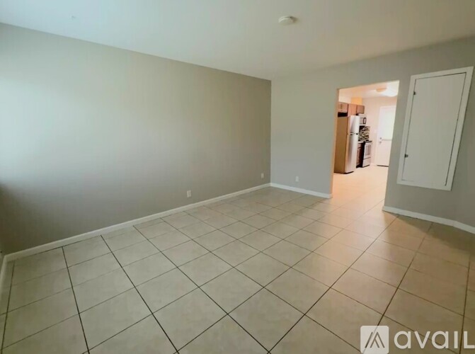 A spacious room with tile flooring and a doorway leading to another room.